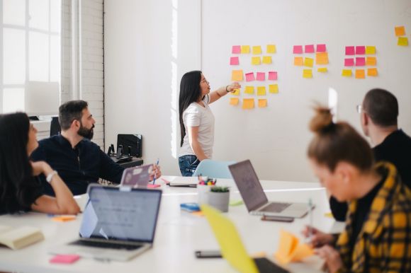 Leadership Training - woman placing sticky notes on wall